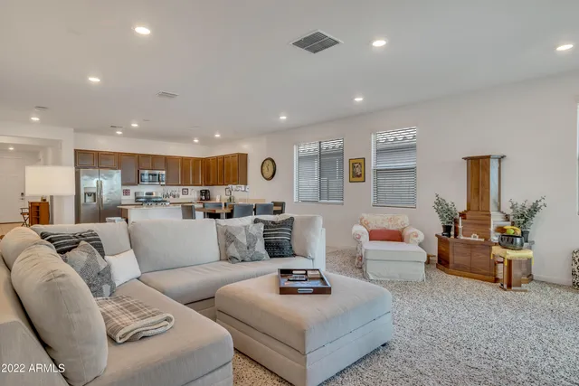 a living room with furniture kitchen view and a large window