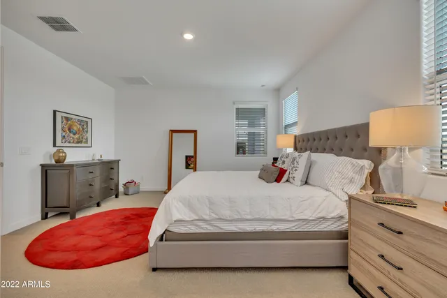 a bedroom with a bed and dresser with mirror