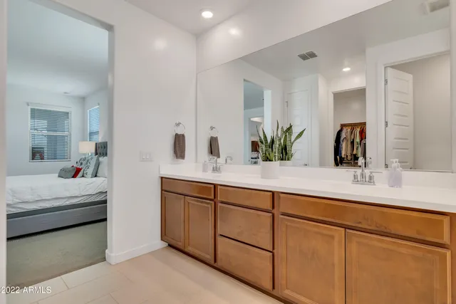 a bathroom with double vanity sinks and a mirror