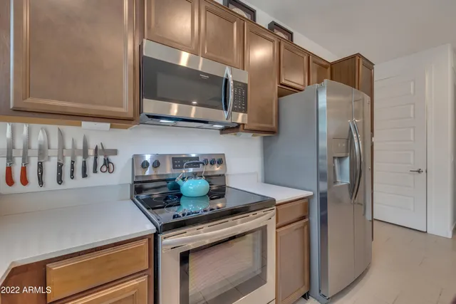 a kitchen with stainless steel appliances granite countertop a refrigerator and a stove