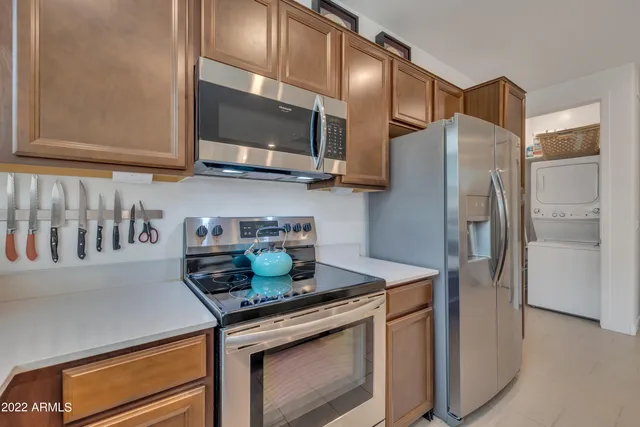 a kitchen with stainless steel appliances granite countertop a refrigerator and a stove top oven