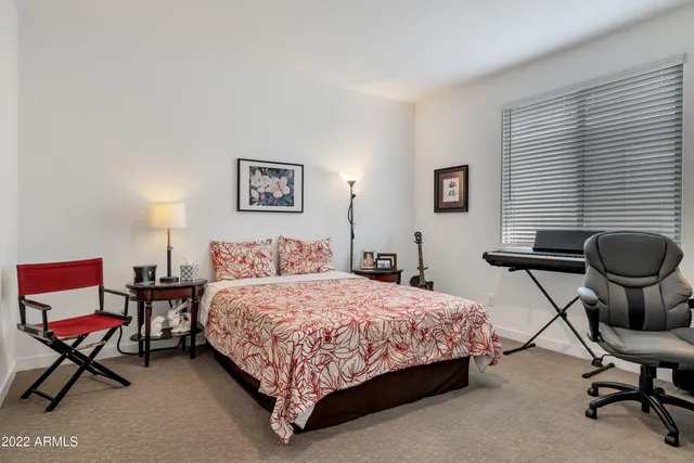 a bedroom with a bed chair and a desk