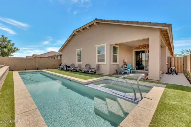 a view of a house with swimming pool and sitting area