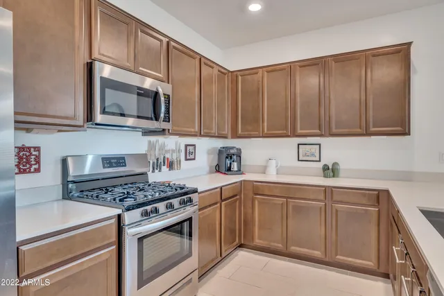 a kitchen with stainless steel appliances granite countertop a stove top oven a sink dishwasher and cabinets with wooden floor