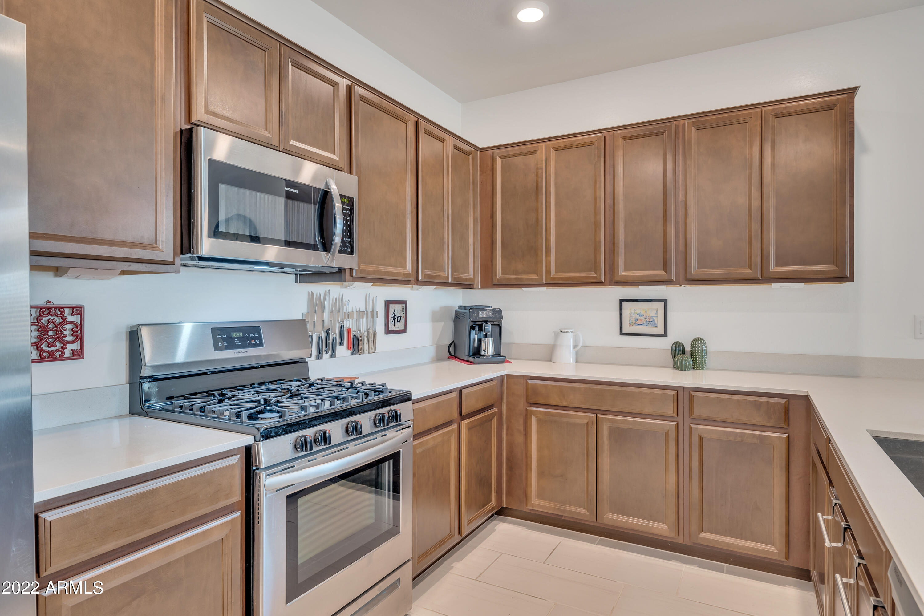 9630 West Atlantis Way Tolleson, AZ 85353 - Photo 7 of 37 a kitchen with stainless steel appliances granite countertop a stove top oven a sink dishwasher and cabinets with wooden floor