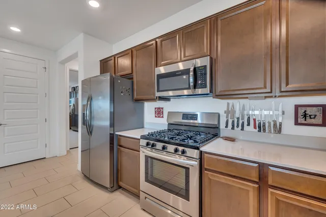 a kitchen with stainless steel appliances granite countertop a refrigerator stove and microwave