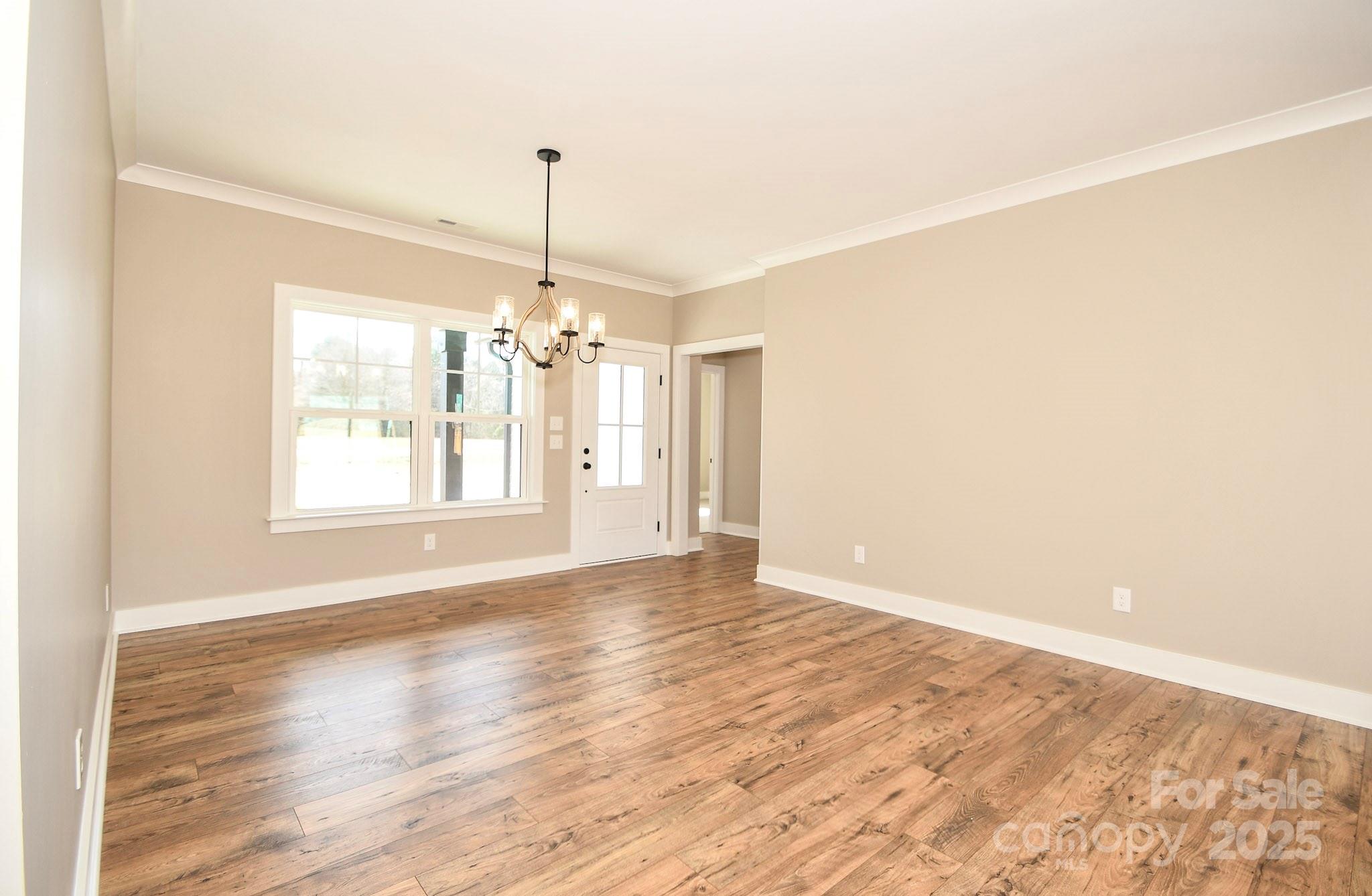 5411 East Lawyers Road Wingate, NC 28174 - Photo 10 of 22 a view of an empty room with window and wooden floor