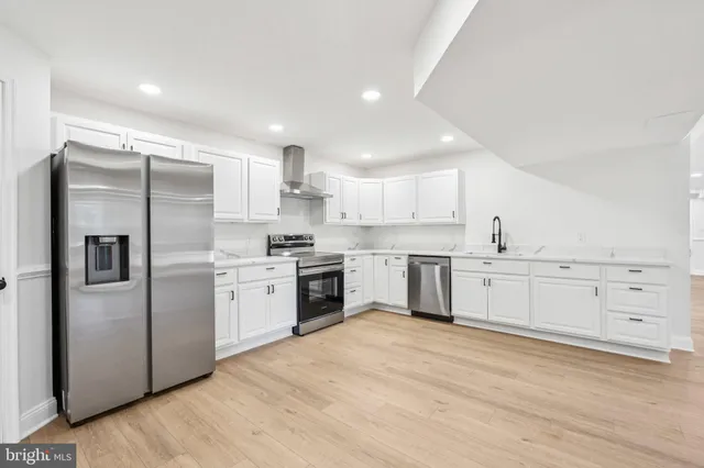 a kitchen with white cabinets and stainless steel appliances