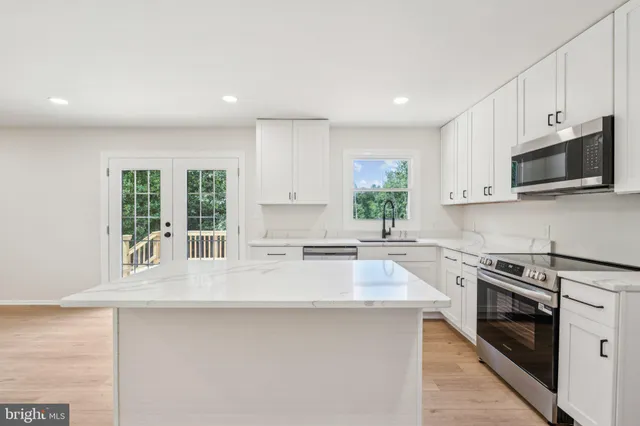 a kitchen with stainless steel appliances granite countertop a stove a sink and a microwave