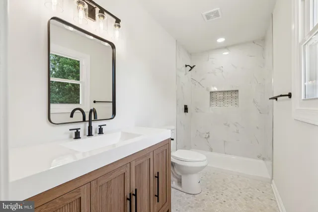 a bathroom with a sink a toilet and shower