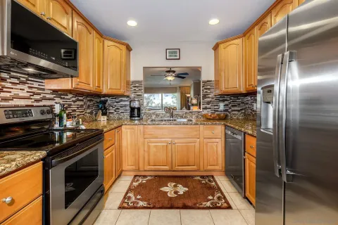 a kitchen with stainless steel appliances granite countertop a stove a sink and a microwave