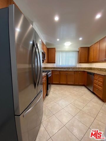 a kitchen with granite countertop a refrigerator and a sink