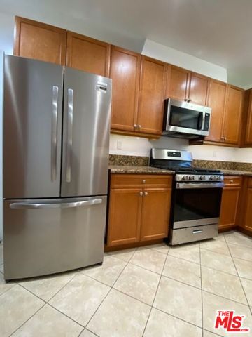 a kitchen with stainless steel appliances granite countertop a refrigerator a stove a sink and a microwave