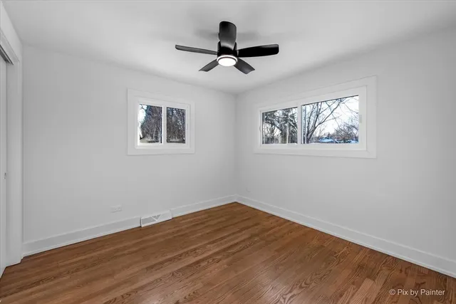 a view of empty room with wooden floor and window