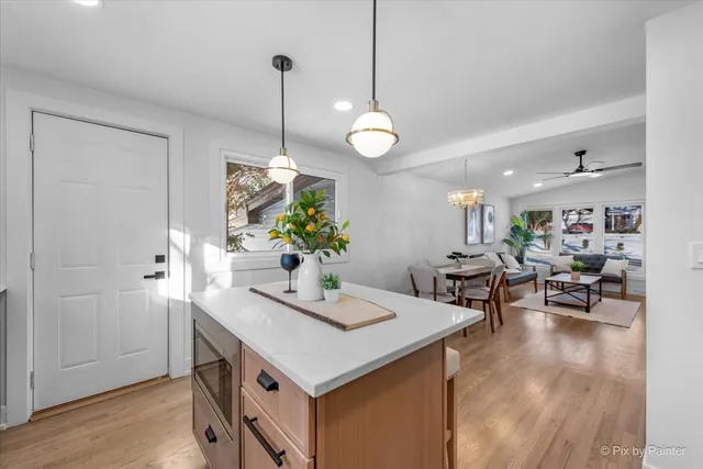 a view of a dining room and livingroom with furniture wooden floor a chandelier