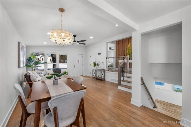 a view of a dining room and livingroom with furniture wooden floor a chandelier