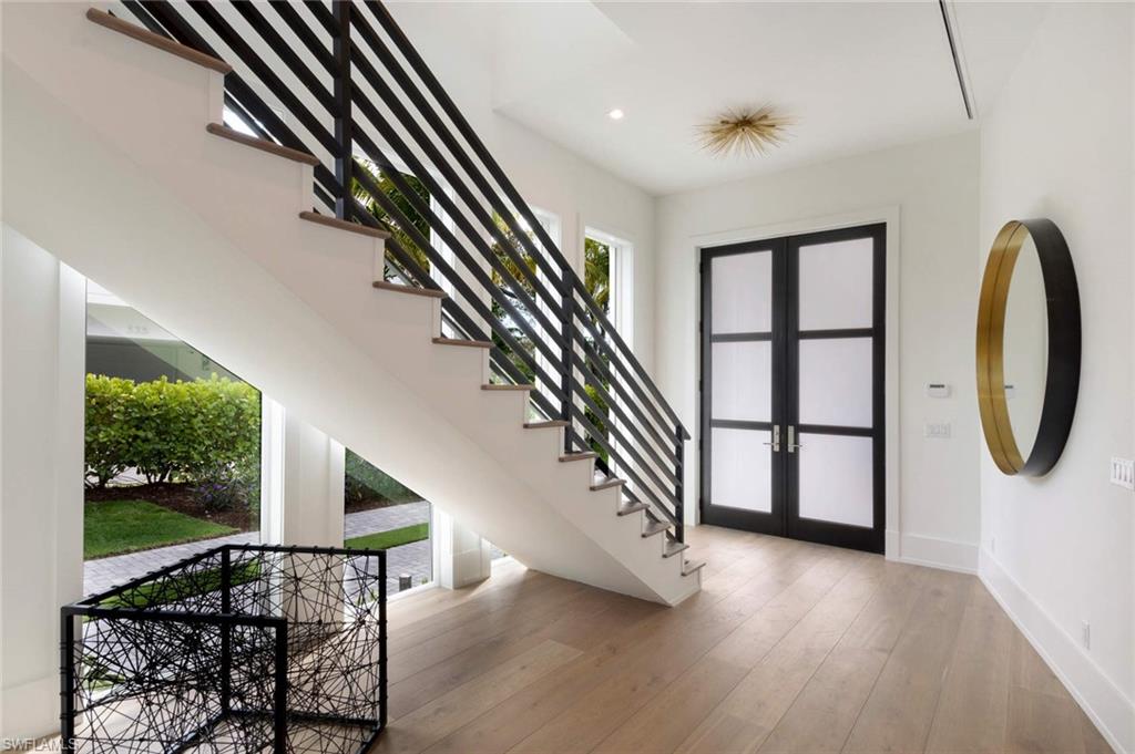 1430 Crayton Road Naples, FL 34102 - Photo 11 of 34 wooden floor with windows and stairs