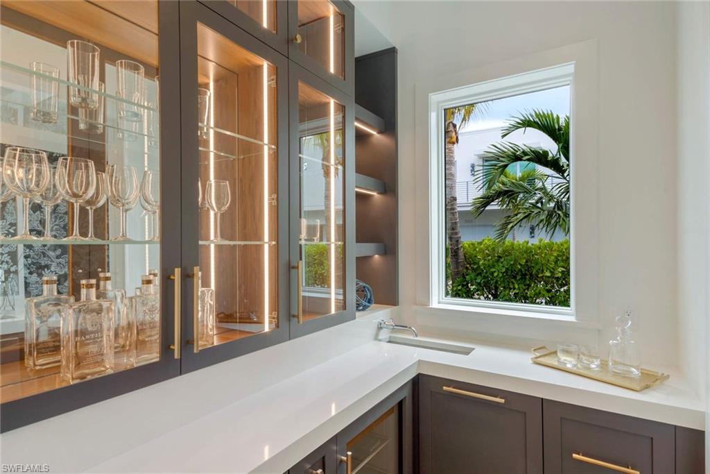 1430 Crayton Road Naples, FL 34102 - Photo 12 of 34 a view of a bathroom with a sink and mirror with next to a window