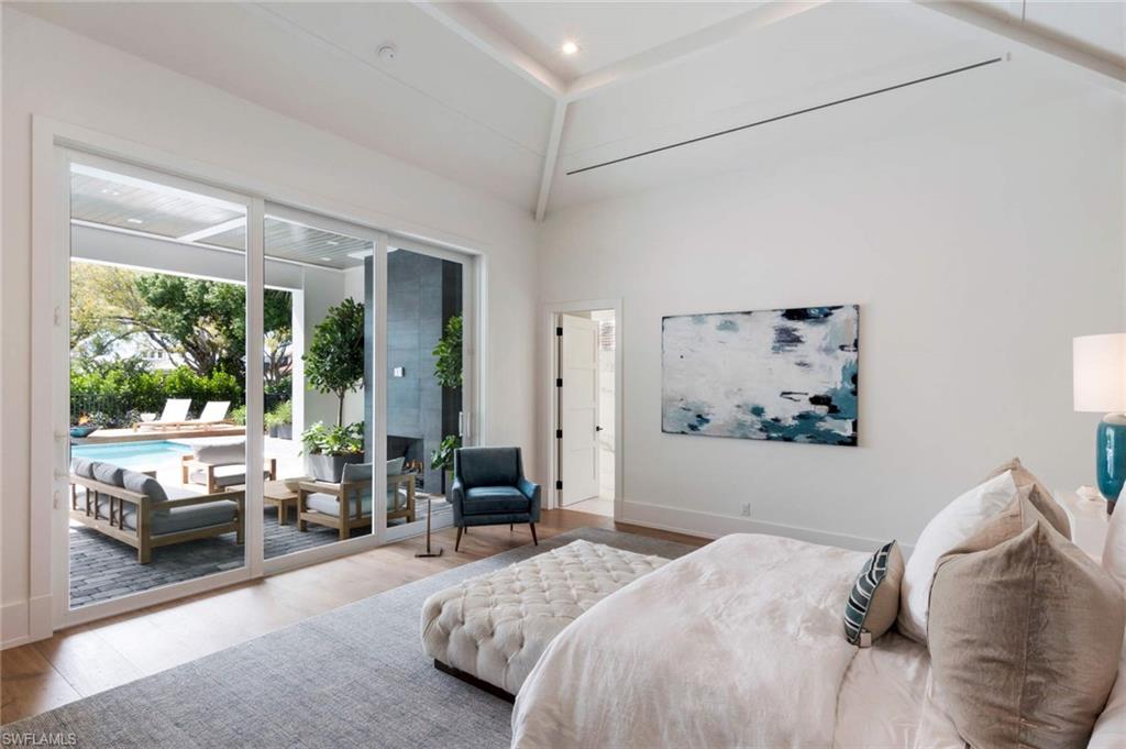 1430 Crayton Road Naples, FL 34102 - Photo 16 of 34 a bedroom with a large bed couch and a large window