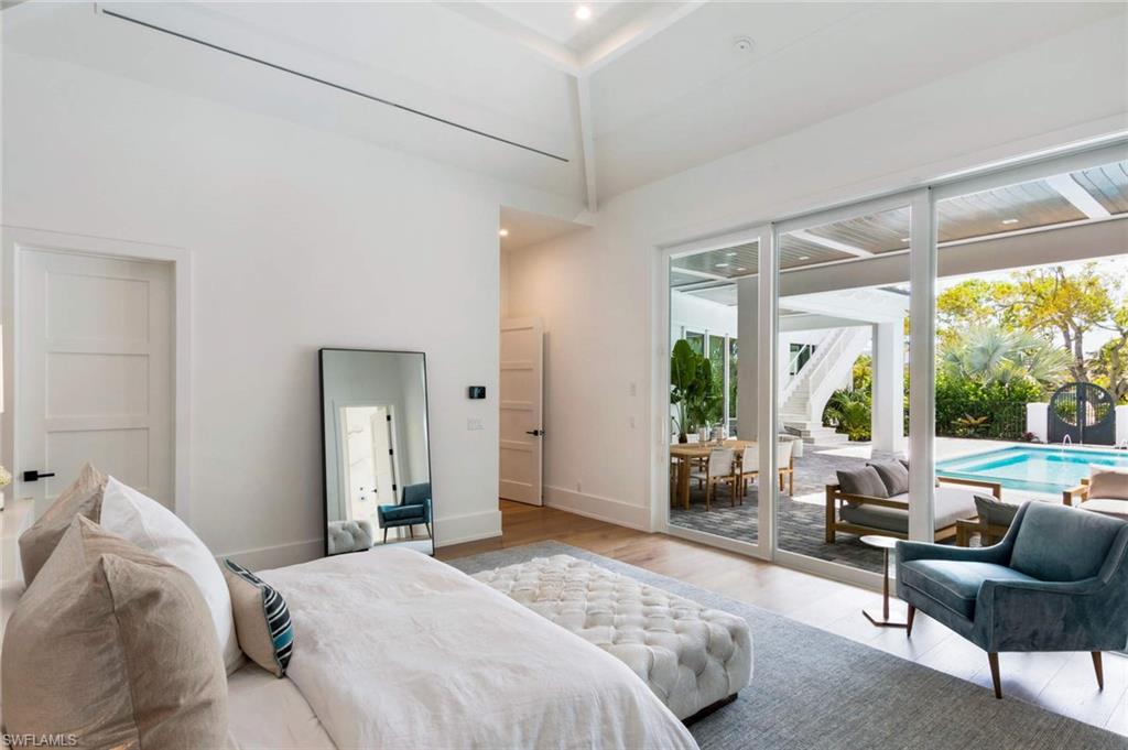 1430 Crayton Road Naples, FL 34102 - Photo 17 of 34 a bedroom with a bed and a large window