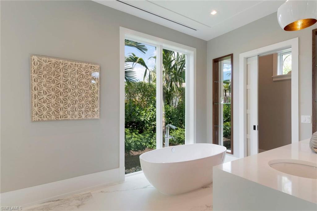 1430 Crayton Road Naples, FL 34102 - Photo 18 of 34 a white bath tub sitting in a bathroom next to a window