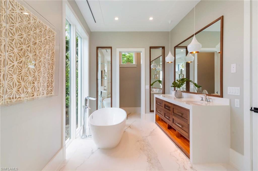 1430 Crayton Road Naples, FL 34102 - Photo 19 of 34 a spacious bathroom with a granite countertop sink and a mirror