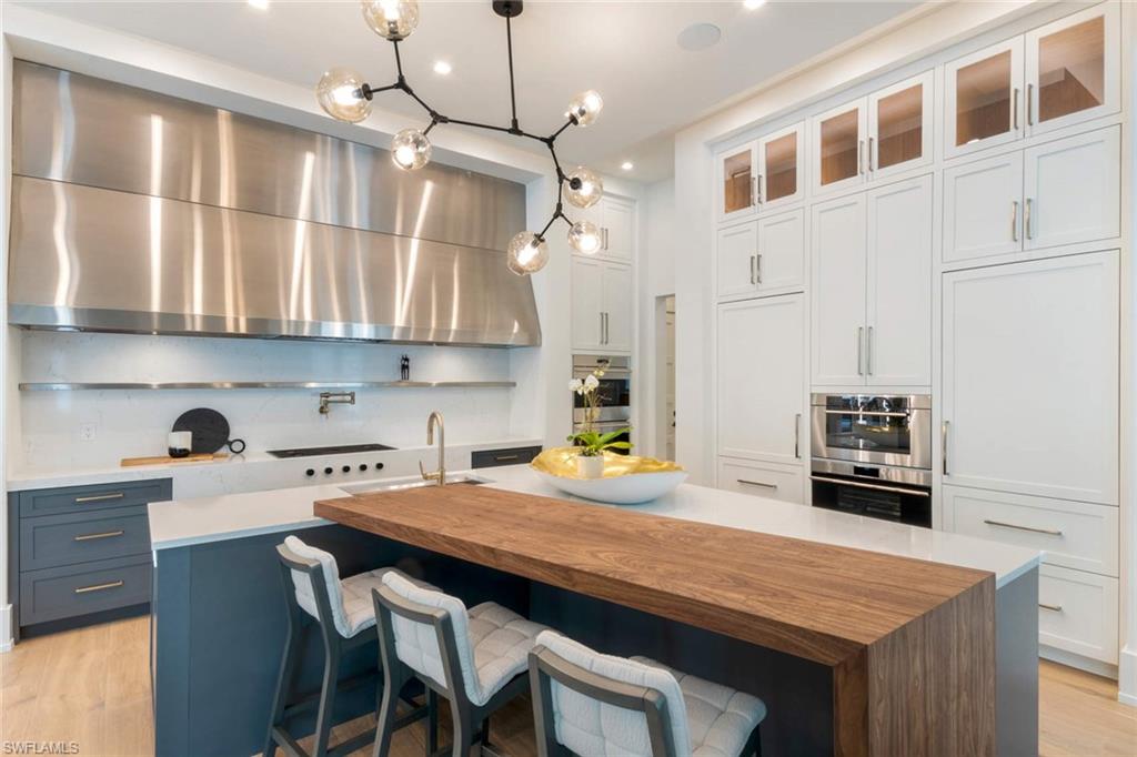 1430 Crayton Road Naples, FL 34102 - Photo 6 of 34 a kitchen with a table chairs and cabinets