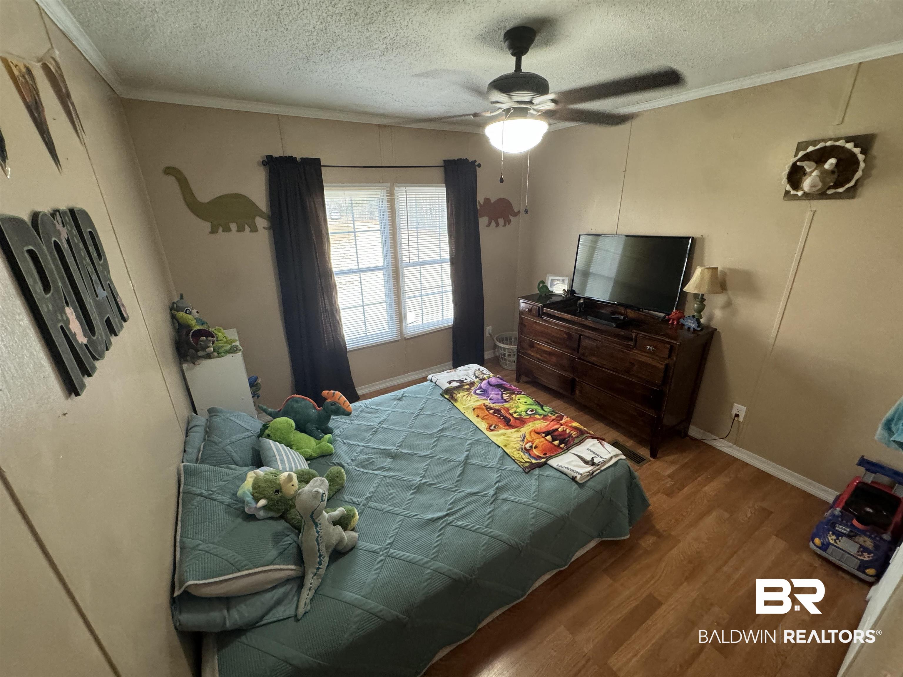 51235 Phillipsville Road Bay Minette, AL 36507 - Photo 36 of 63 Bedroom featuring a textured ceiling, ornamental molding, dark wood-style floors, and ceiling fan