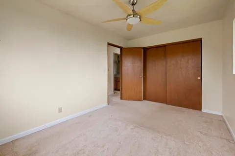a view of an empty room with a chandelier fan