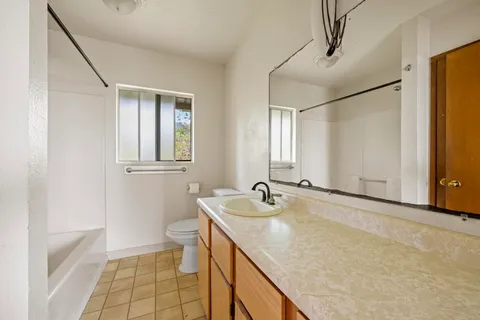 a bathroom with a sink a toilet and a mirror