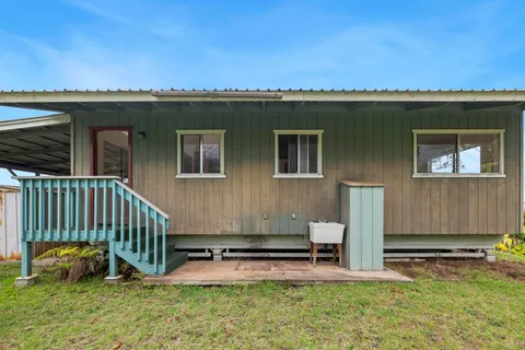 a view of a house with a patio and a yard