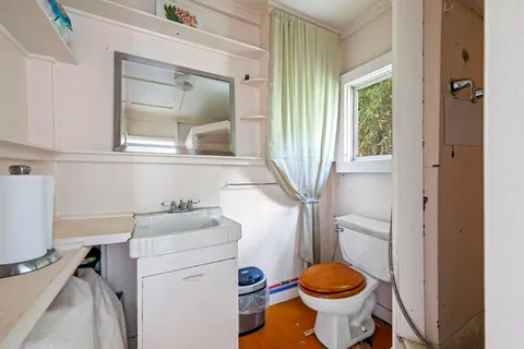 a bathroom with a sink toilet and a mirror