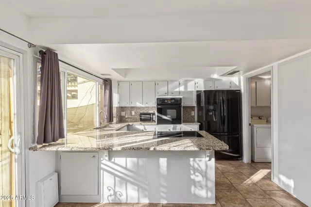 a kitchen with stainless steel appliances granite countertop a refrigerator and a sink