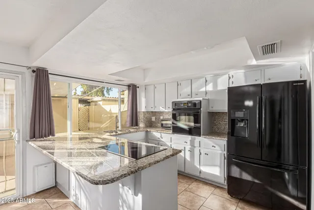 a kitchen with stainless steel appliances granite countertop a refrigerator stove and sink