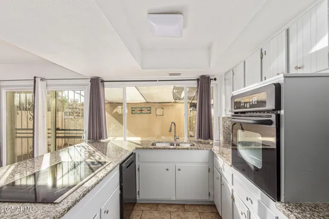 a kitchen with granite countertop a refrigerator stove and sink