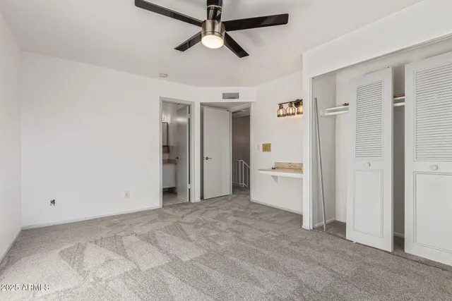 a view of a livingroom with a chandelier fan and refrigerator