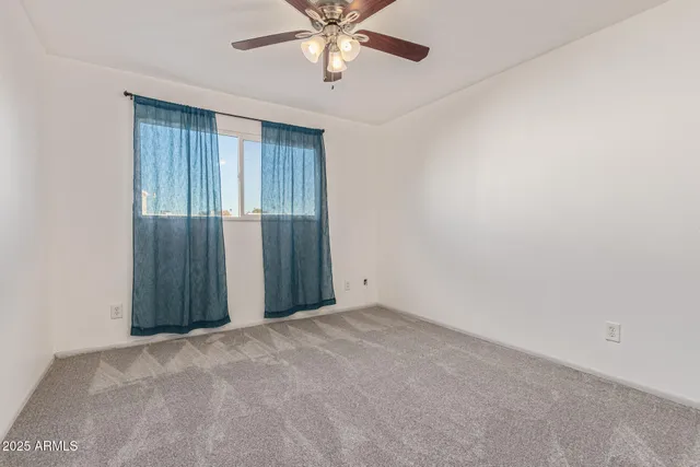 an empty room with closet and fan