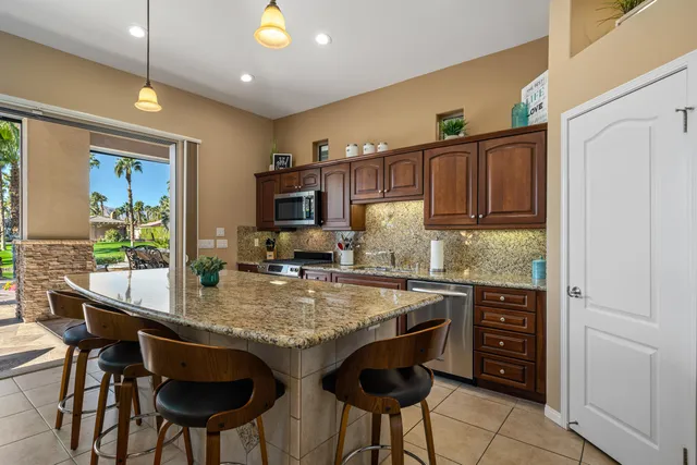 a living room with furniture kitchen and a chandelier