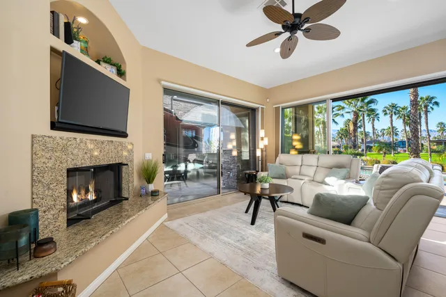 a living room with furniture a fireplace and a chandelier