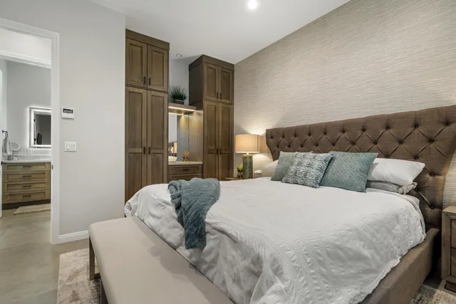 a bathroom with a granite countertop sink a toilet a mirror and shower