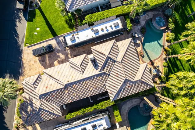 a view of a backyard with swimming pool and sitting area