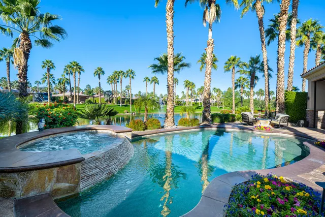 a view of a patio with couches table and chairs potted plants and palm tree