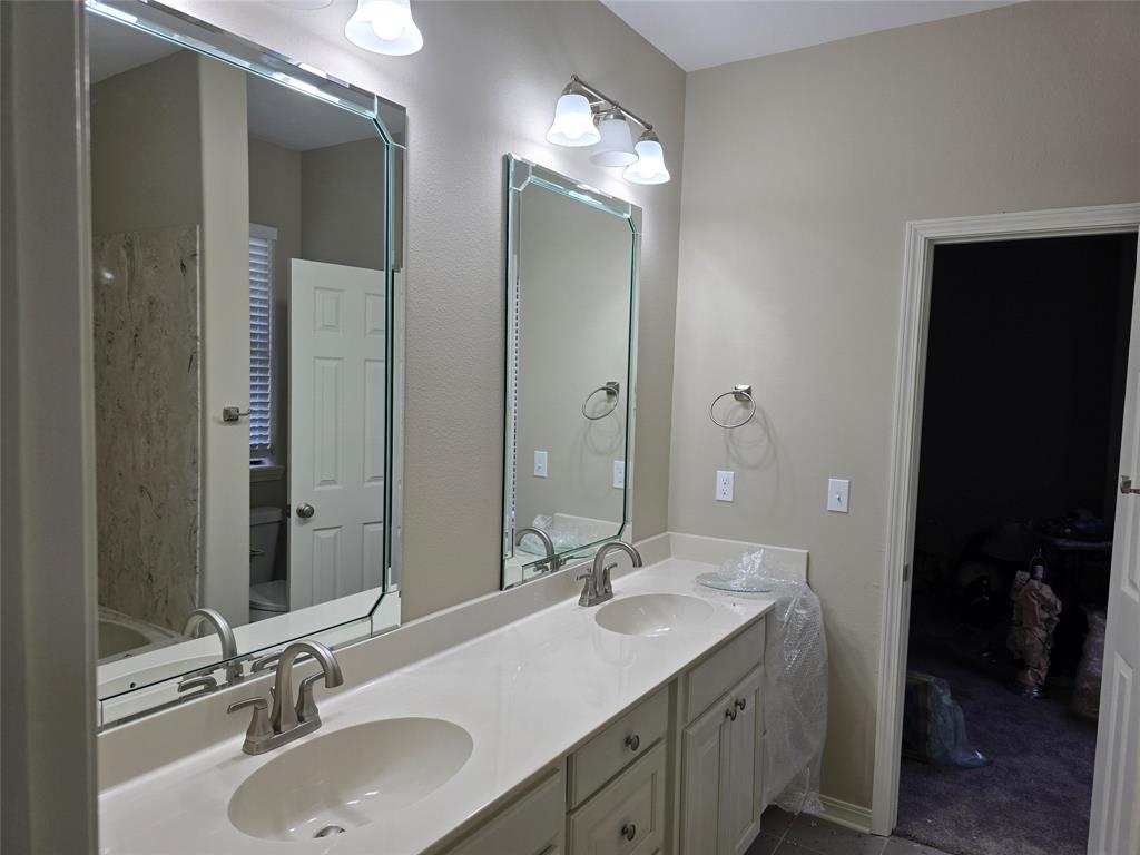 10407 Bethany State Line Road Bethany, LA 71007 - Photo 16 of 19 a bathroom with double vanity sinks and a mirror