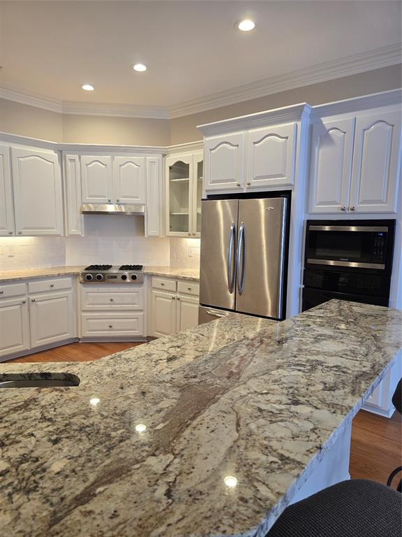 10407 Bethany State Line Road Bethany, LA 71007 - Photo 10 of 30 a kitchen with stainless steel appliances granite countertop a refrigerator a stove and a sink with wooden cabinets