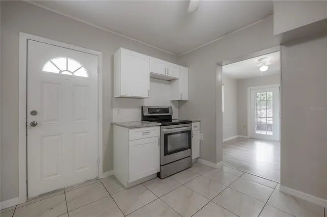 a kitchen with a refrigerator and white cabinets