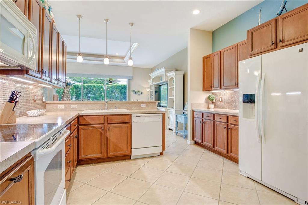 9258 Springview Loop Estero, FL 33928 - Photo 4 of 35 a kitchen with stainless steel appliances sink stove and cabinets
