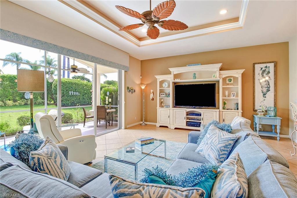 9258 Springview Loop Estero, FL 33928 - Photo 7 of 35 a living room with furniture a flat screen tv and a floor to ceiling window