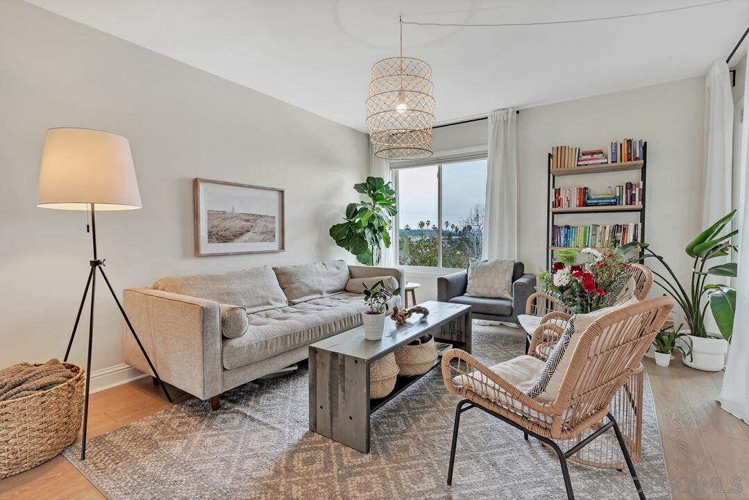 1855 Diamond Street, Unit 228 San Diego, CA 92109 - Photo 1 of 27 a living room with furniture and a chandelier