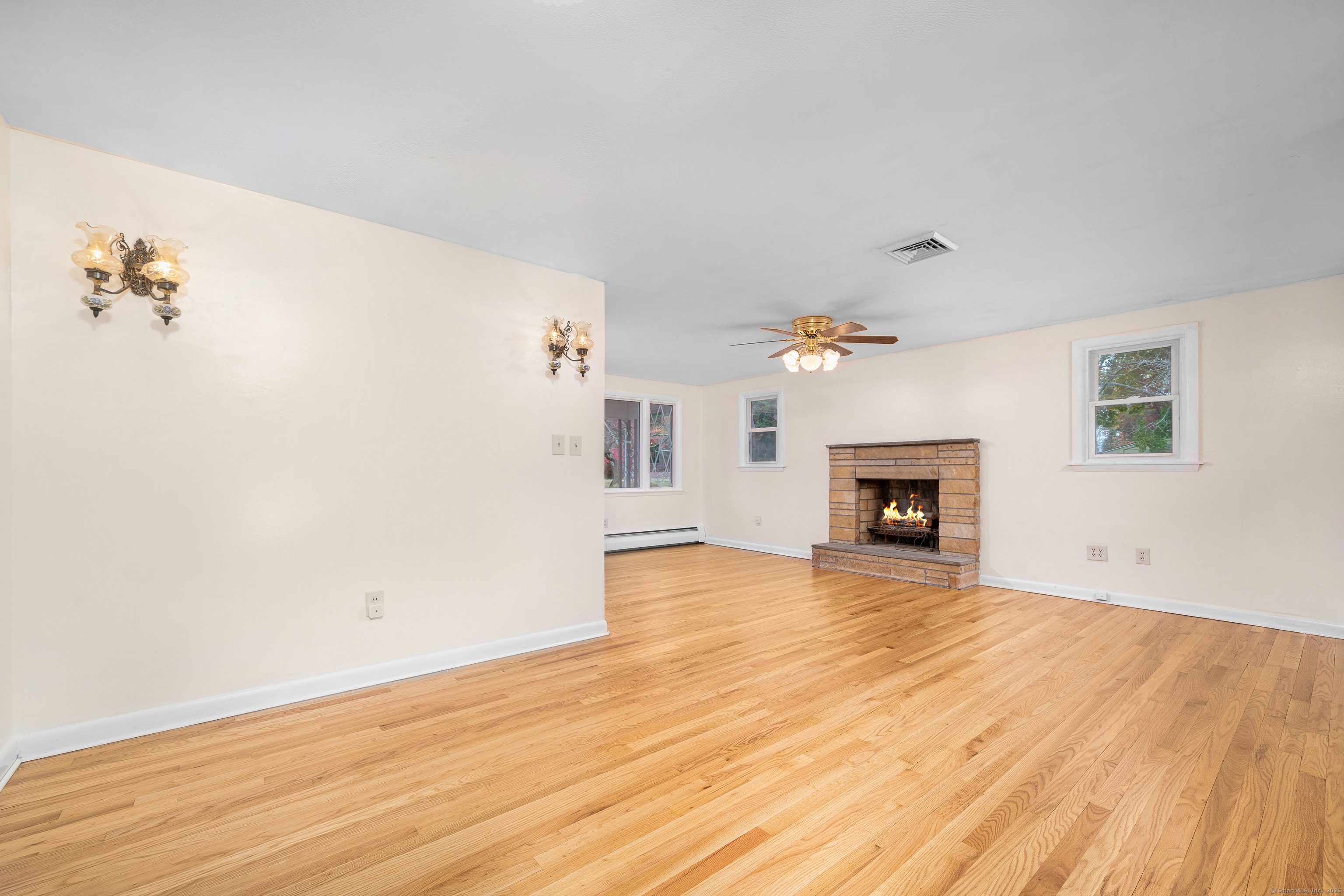 110 Coles Road Cromwell, CT 06416 - Photo 10 of 40 a view of empty room with wooden floor and fireplace