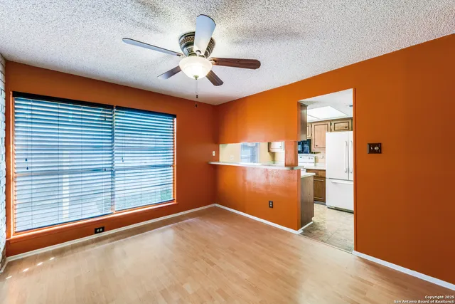 a view of a livingroom with a chandelier fan and a large window